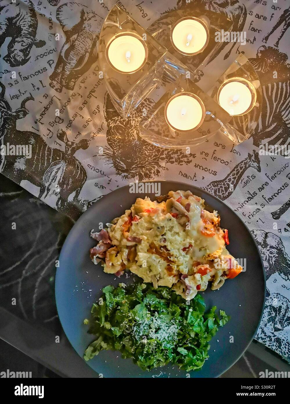 Elevated view of Spanish omelette with salad by candlelight Stock Photo