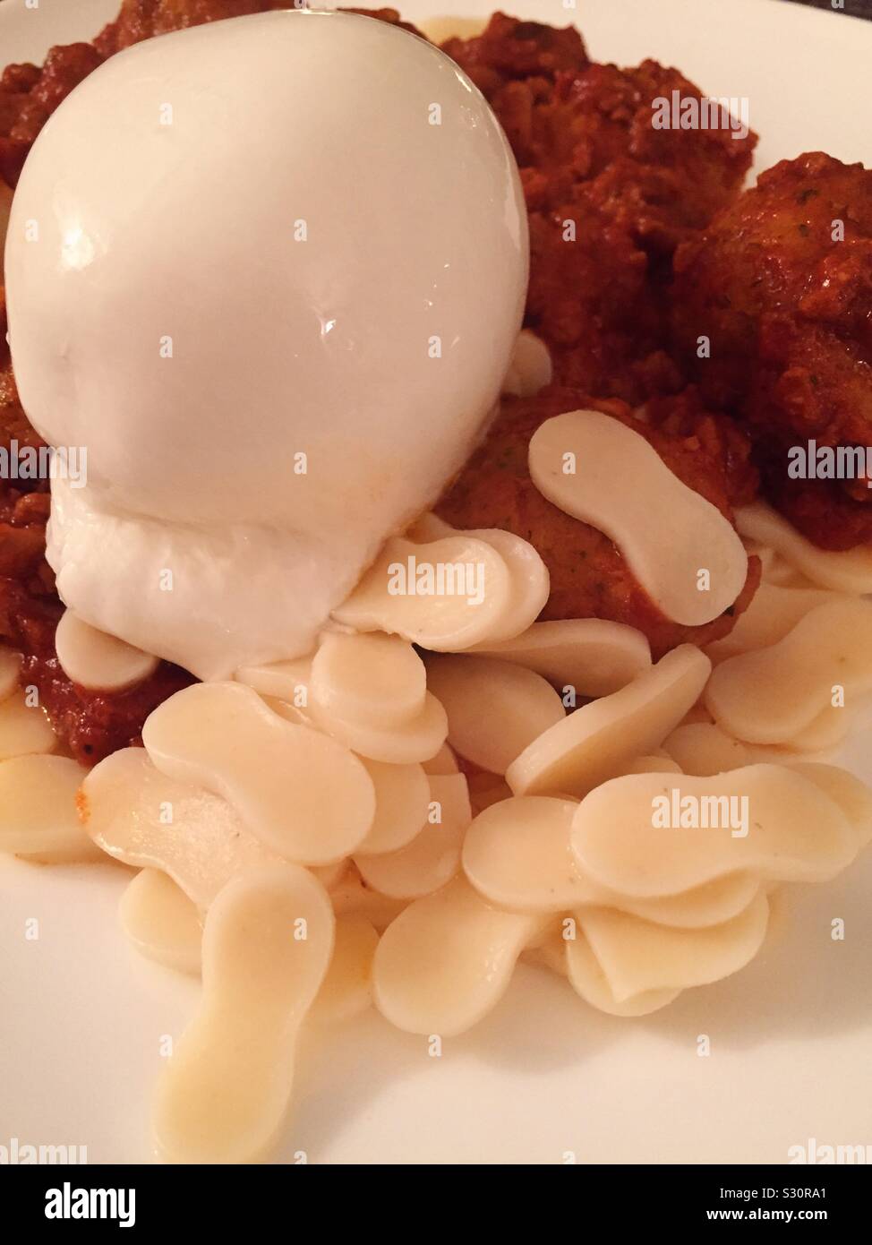 Close up of a pasta dish of burrata cheese, meat sauce and croxetti pasta - Smartphone Captured Stock Image