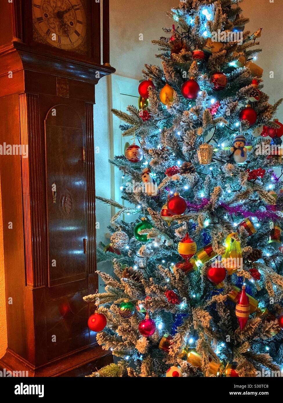 Decorated Christmas tree with baubles tinsel berries Stock Photo