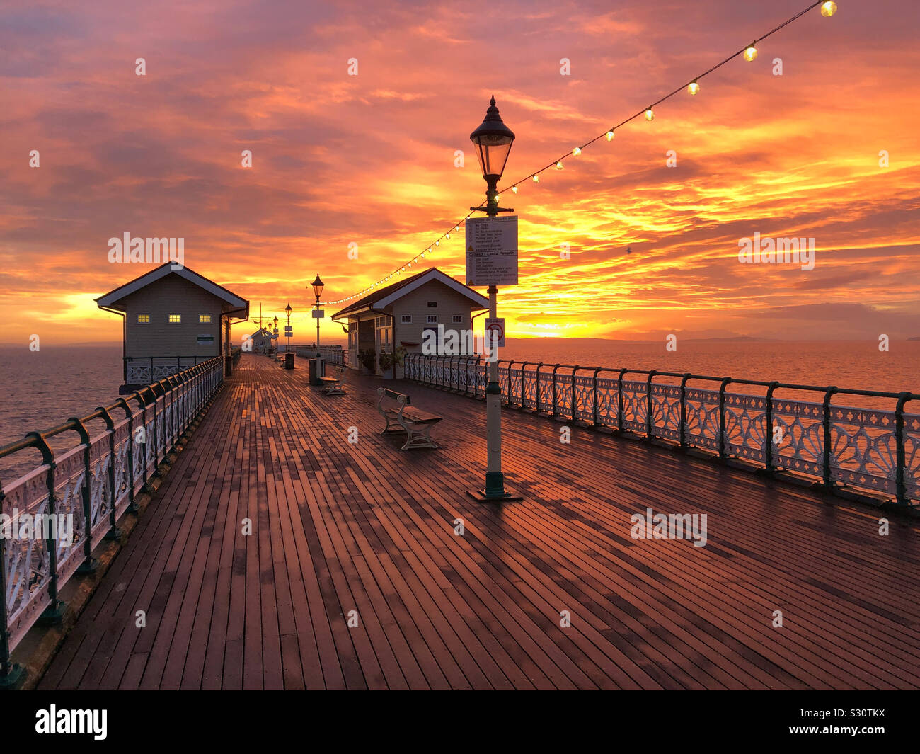 A fiery winter sunrise over Penarth pier, South Wales, December. - Smartphone Captured Stock Image