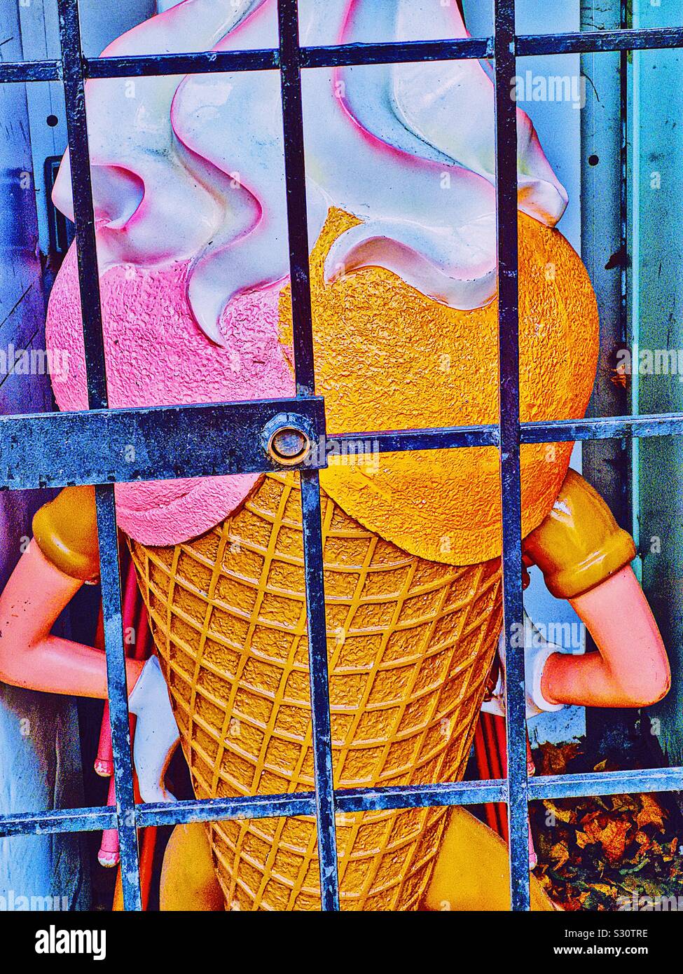 Giant plastic icecream with arms behind bars in winter storage, Sweden Stock Photo