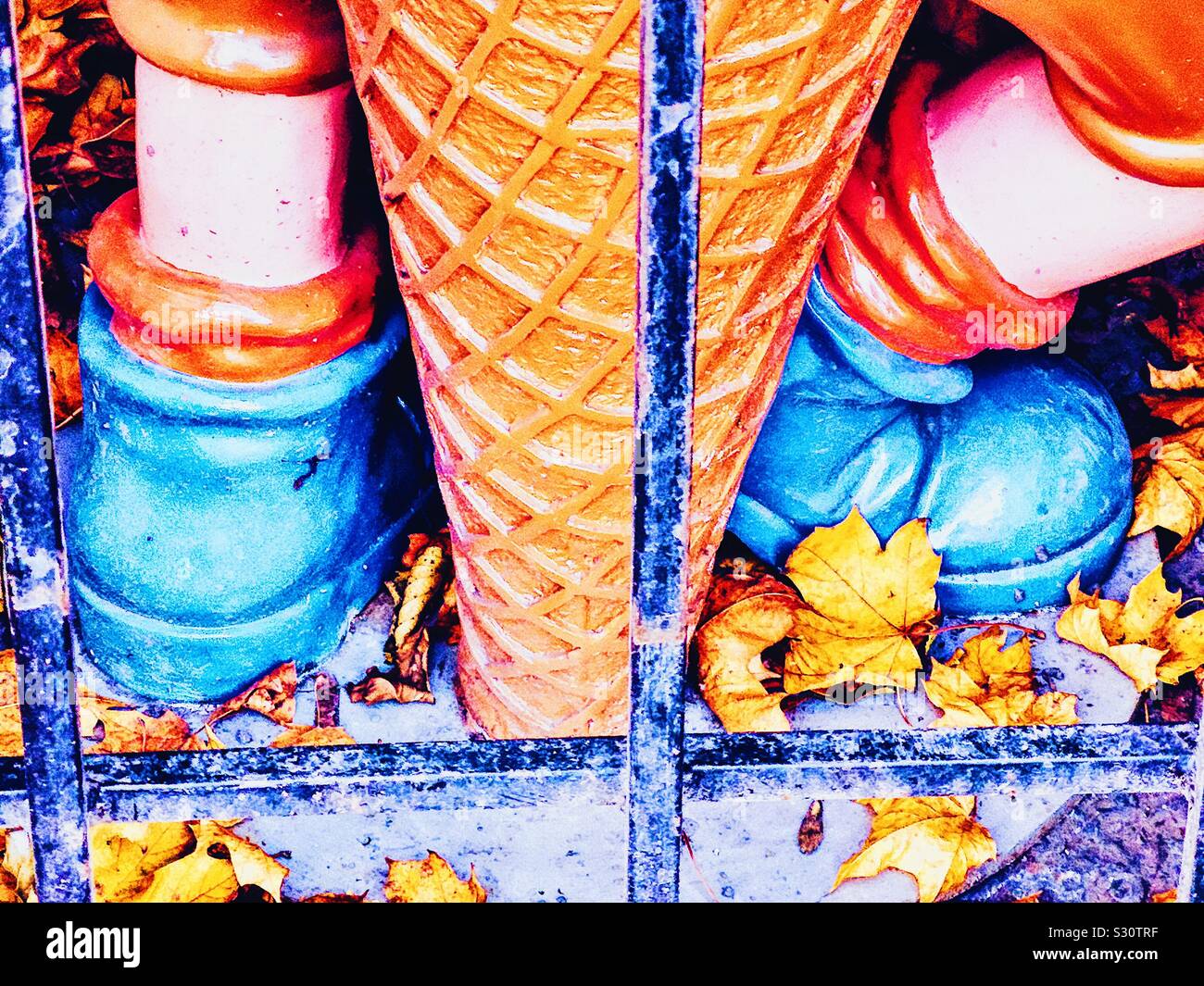 Blue boots and giant plastic icecream amongst autumn leaves in storage for winter, Sweden Stock Photo
