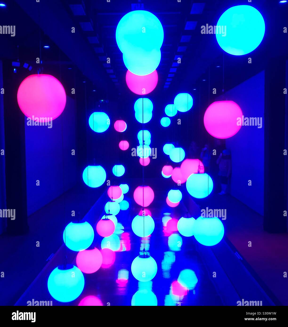 Art installation and kinetic light sculpture for Christmas with lighted orbs raised and lowered to form patterns to music. Stock Photo