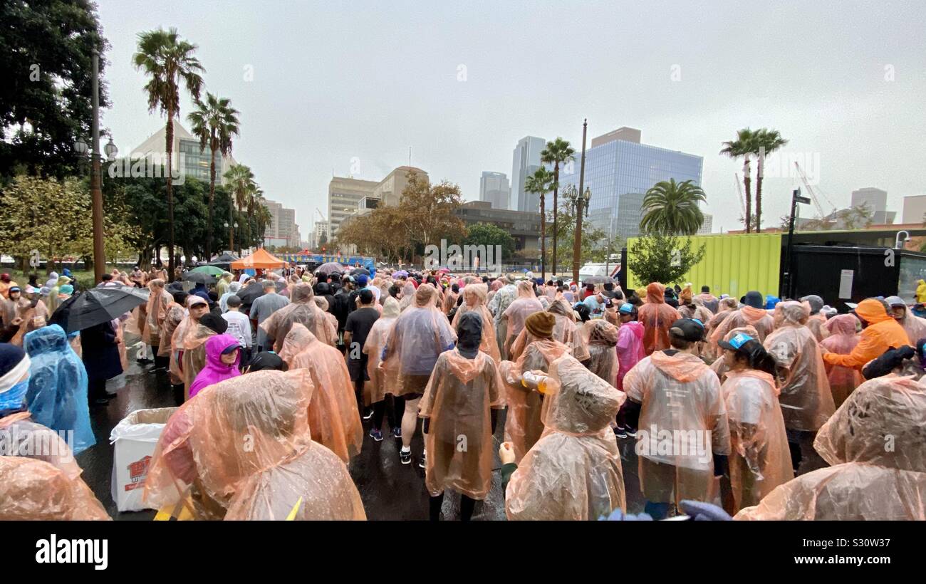 LOS ANGELES, CA, NOV 2019: runners in rain coats crowd towards the start line for the annual Turkey Trot 5K race on Thanksgiving in Downtown - Smartphone Captured Stock Image