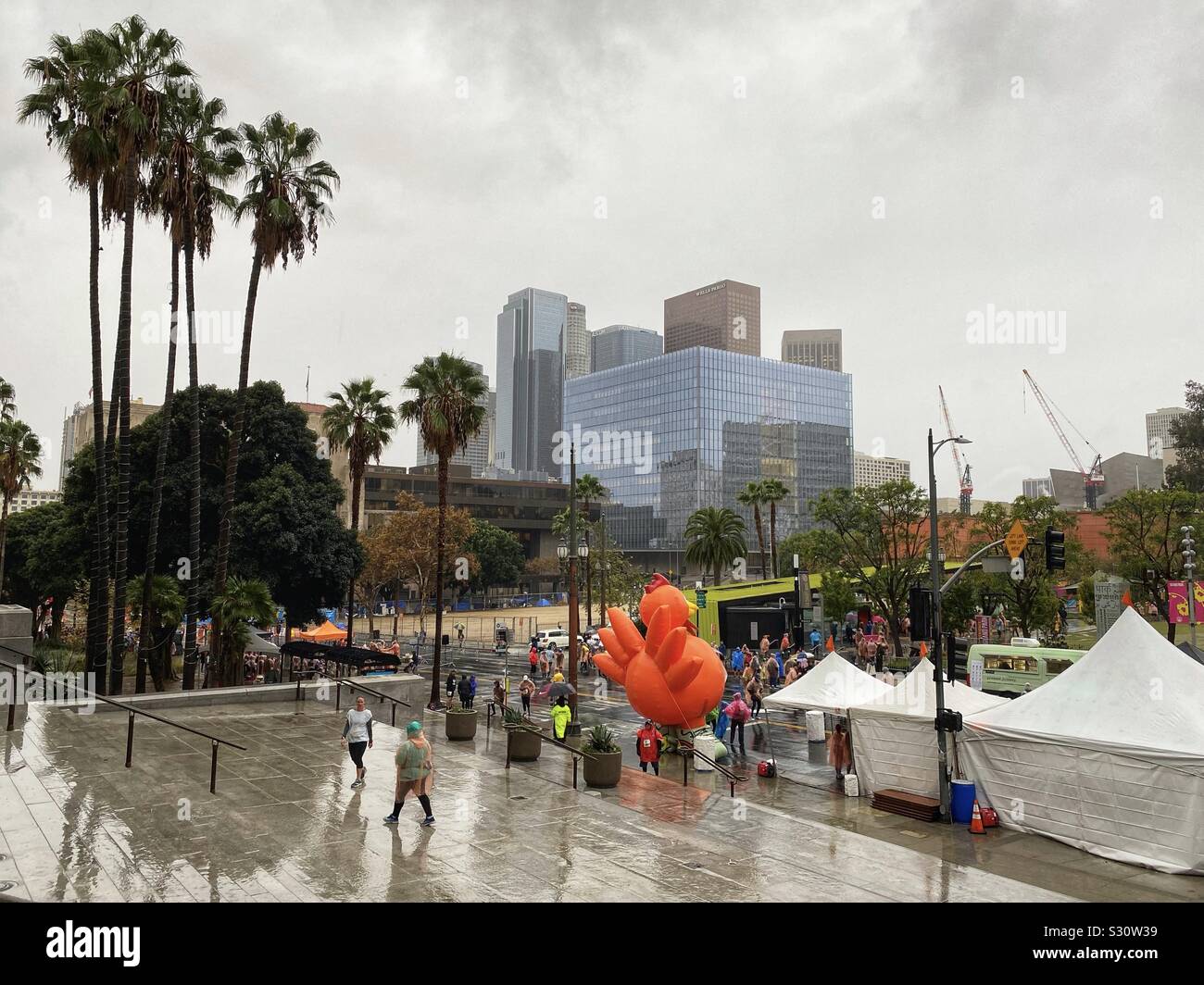 LOS ANGELES, CA, NOV 28, 2019: runners in rain coats arrive to wet conditions outside City Hall for the annual Turkey Trot 5K race on Thanksgiving in Downtown - Smartphone Captured Stock Image