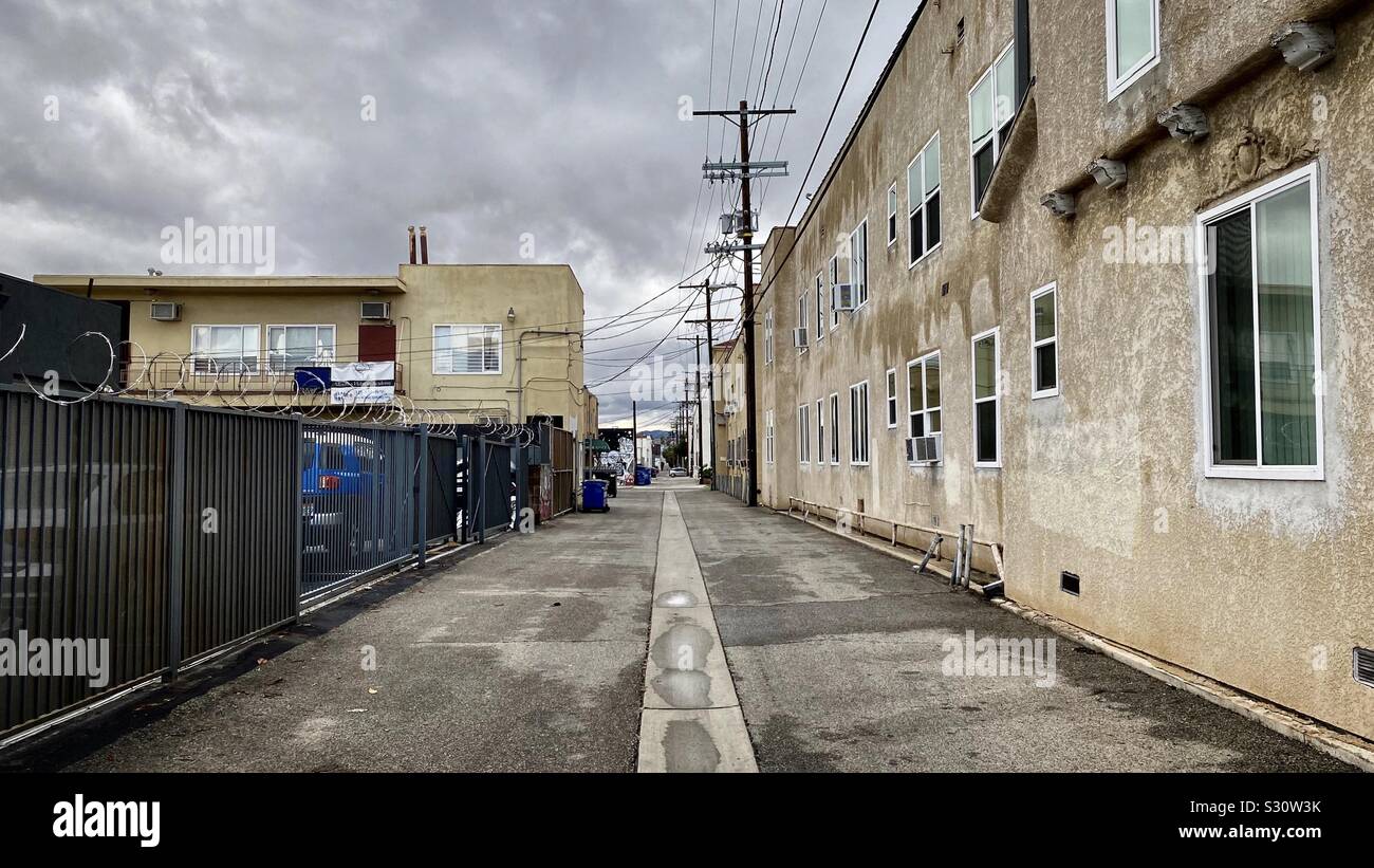 LOS ANGELES, CA, NOV 2019: alleyway between commercial buildings in Hollywood area on an overcast day with puddles on ground Stock Photo