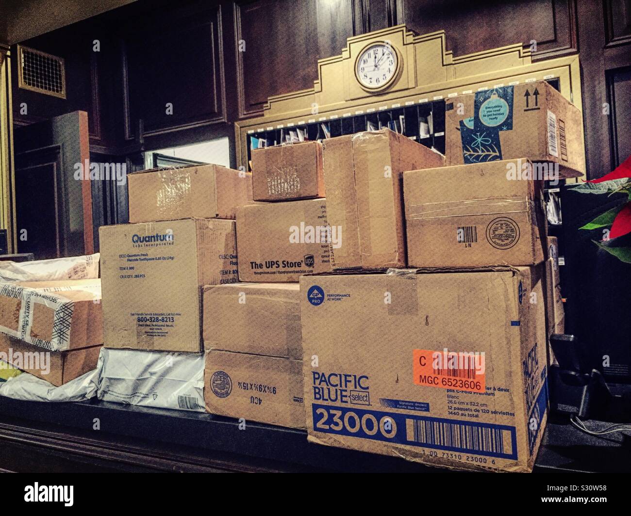 Packing box delivery overwhelms in apartment house lobby front desk, New York City, USA - Smartphone Captured Stock Image