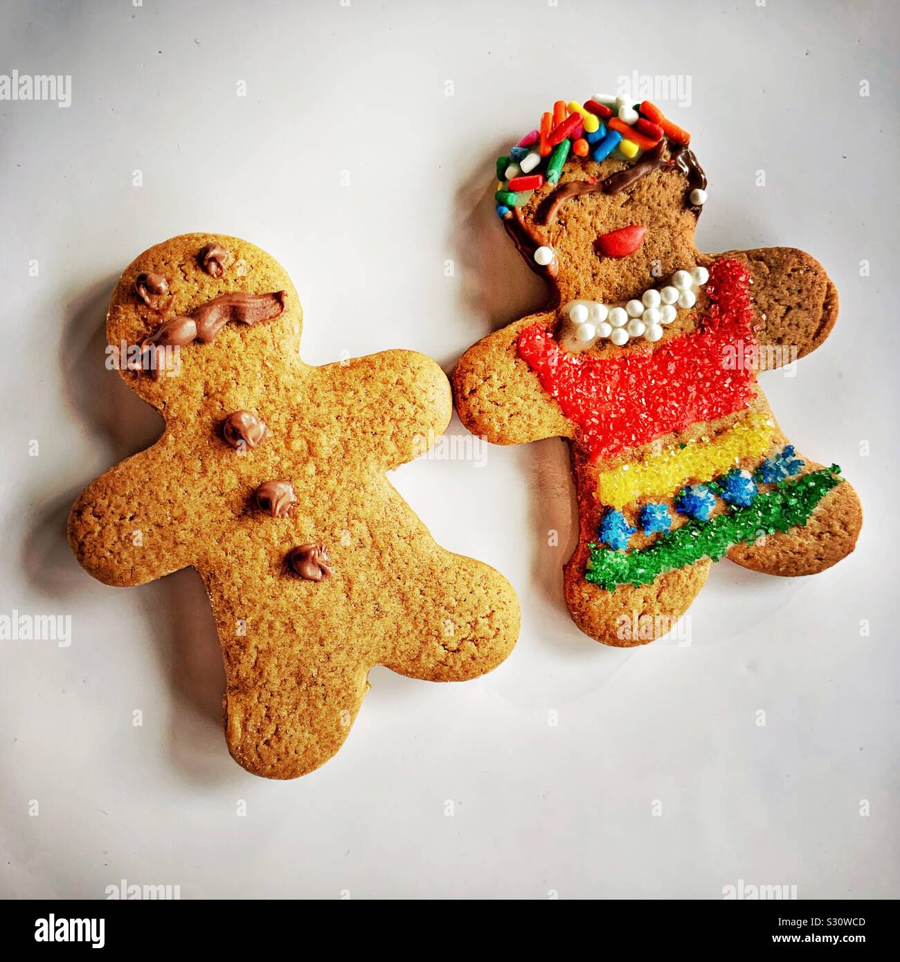 A gingerbread couple is dressed like a man with a mustache and a woman dressed like Freida Kahlo. Stock Photo