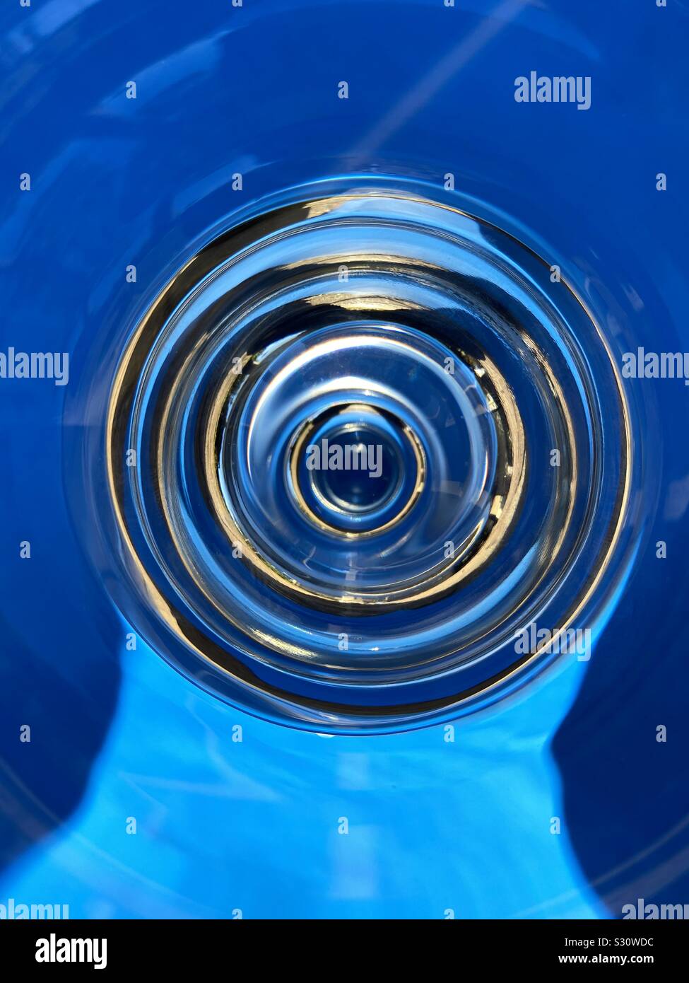 Abstract of a glass with water using natural outdoor light and blue background - Smartphone Captured Stock Image