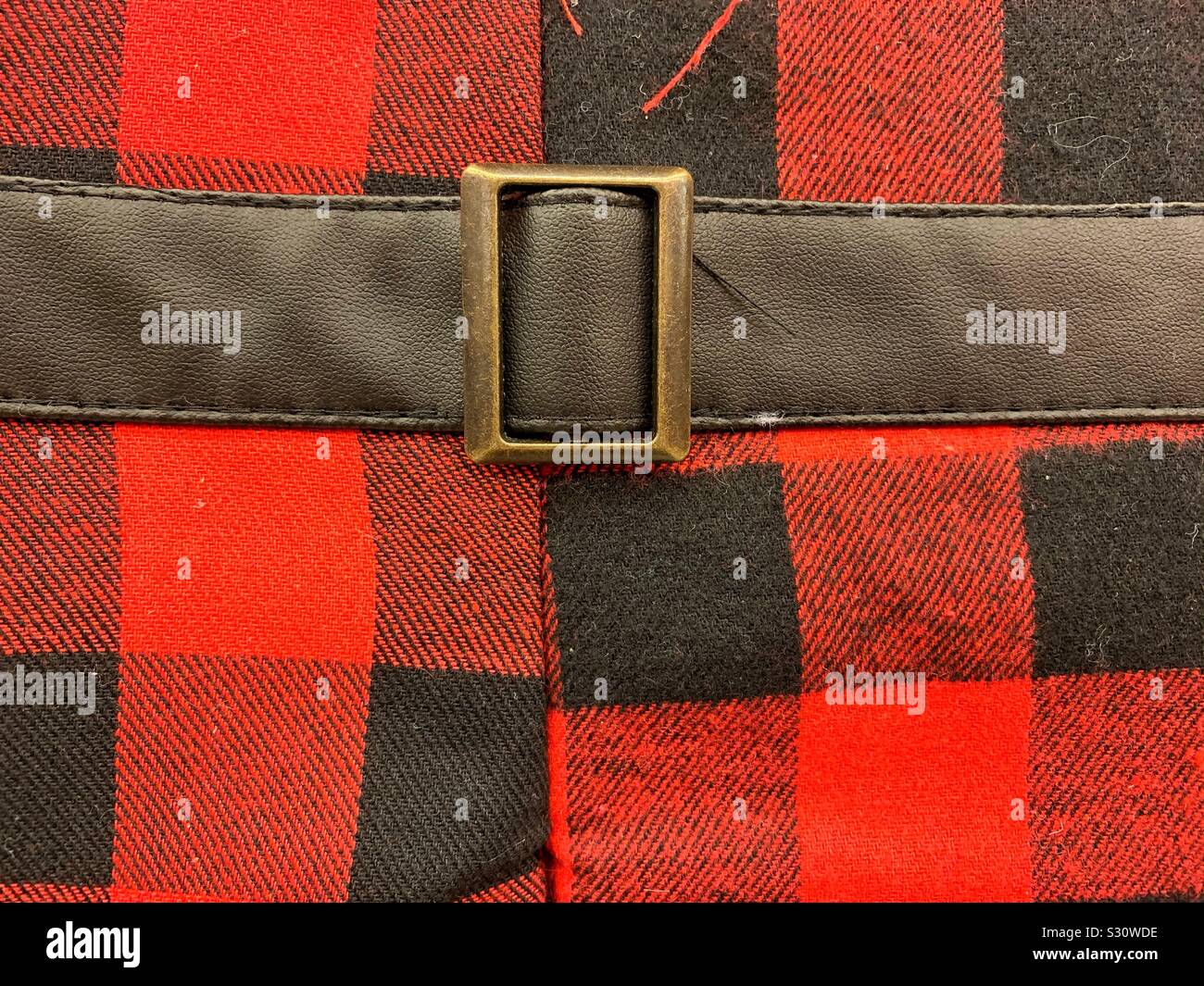 Black Santa belt on a red and black checkered holiday Christmas pattern cloth - Smartphone Captured Stock Image