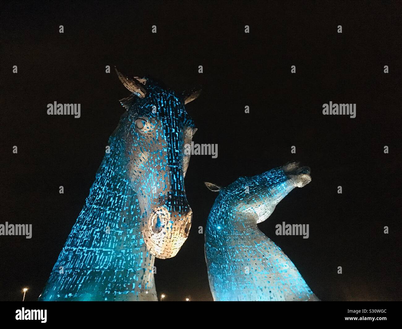 The Kelpies at night, lit up in light blue. Giant Horse Head Sculptures