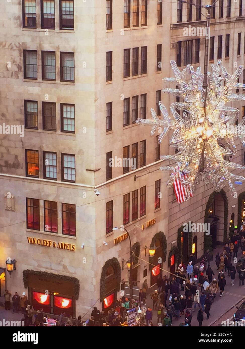 During the holiday season the giant UNICEF snowflake hangs in the intersection of 57th St. and fifth Avenue in midtown Manhattan, NYC, USA - Smartphone Captured Stock Image