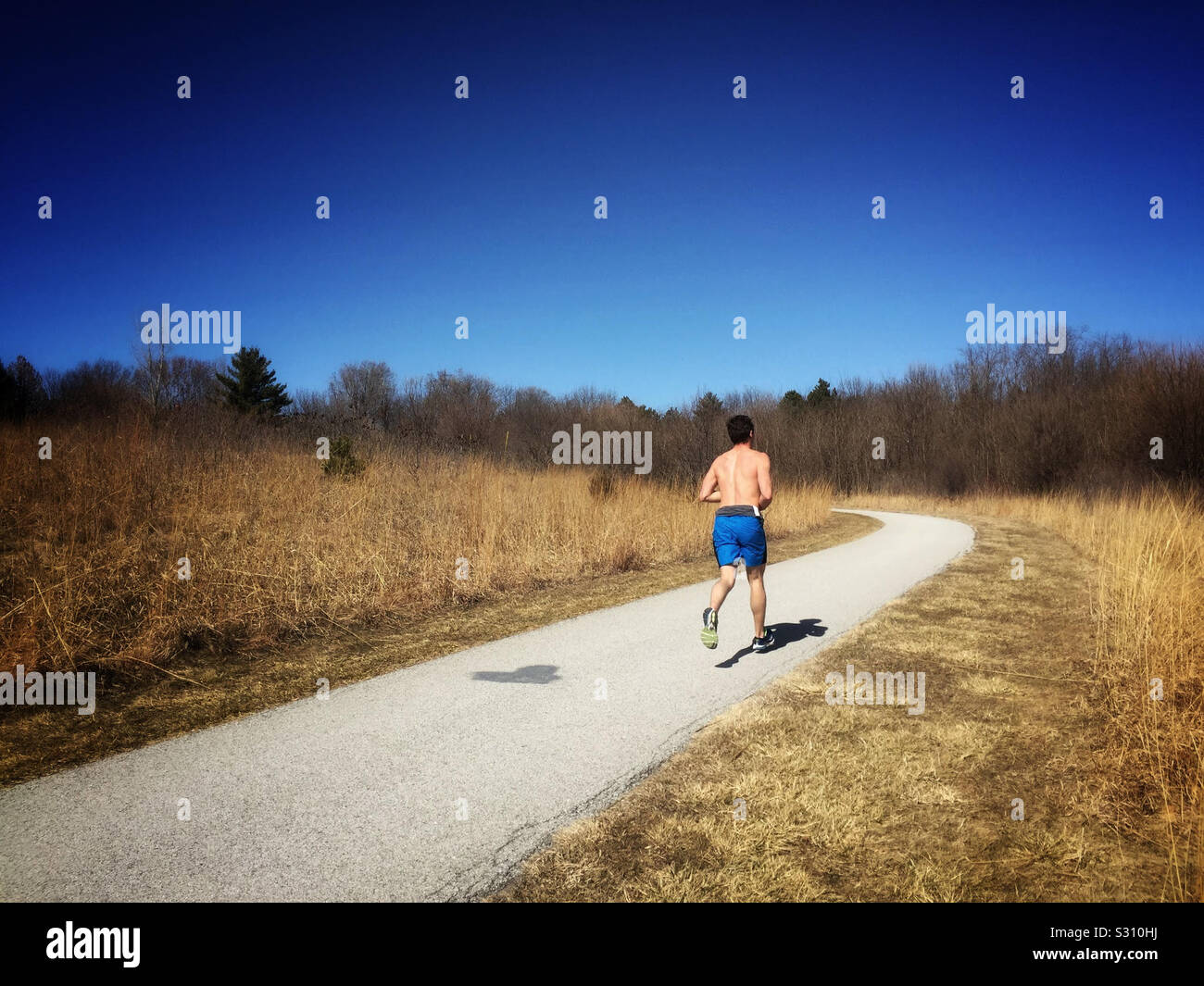 Jogger on a curving country road - Smartphone Captured Stock Image