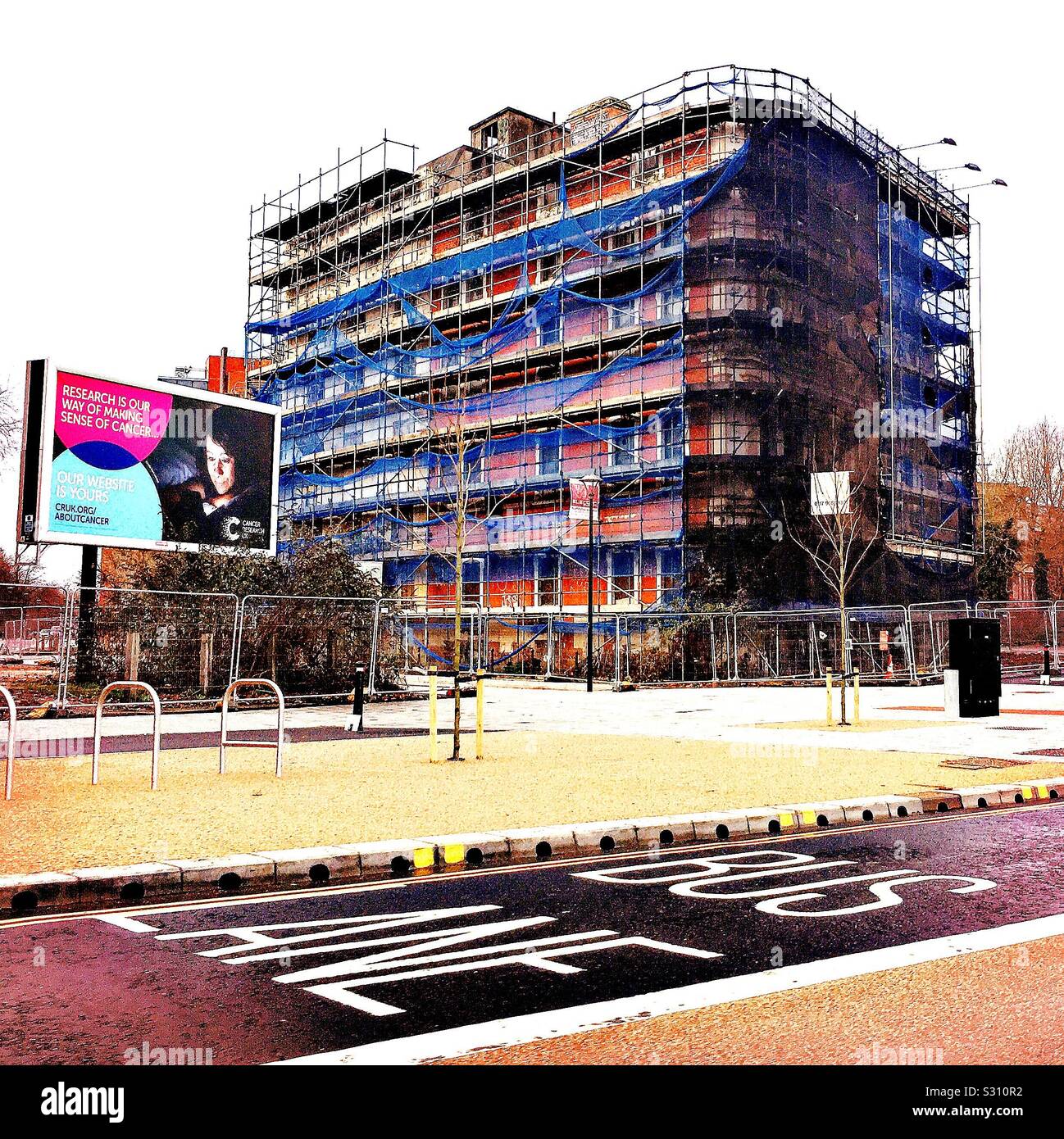 Large building with scaffolding, by a bus lane in Bristol, UK Stock