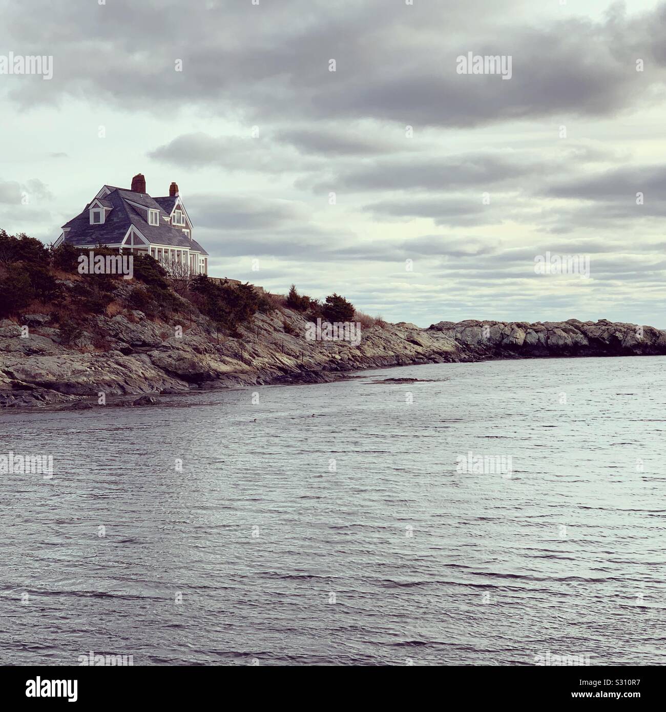 A home on the water under stormy skies in Newport, Rhode Island, United States - Smartphone Captured Stock Image