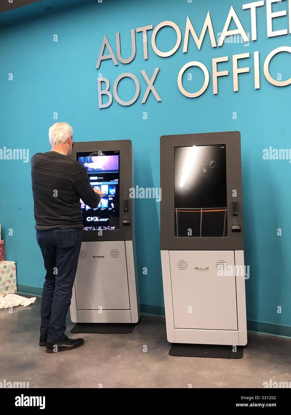 Senior man at an  automated box office purchasing a movie ticket. - Smartphone Captured Stock Image