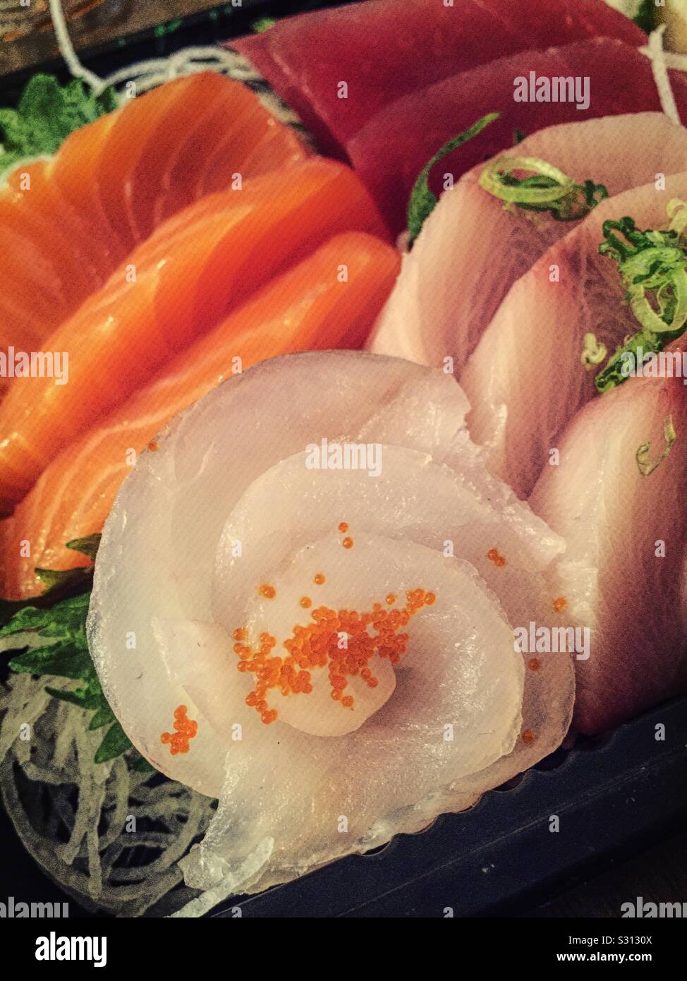 Close up of a Japanese sashimi meal featuring an assortment of fresh pieces of fish - Smartphone Captured Stock Image