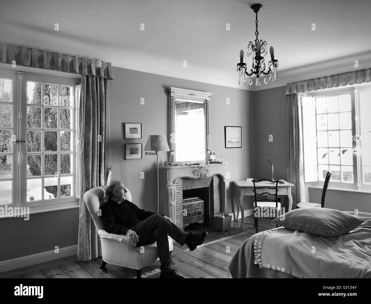 Man looking through a window in a classic style room - Smartphone Captured Stock Image Man looking through a window in a classic style room - Smartphone Captured Stock Image
