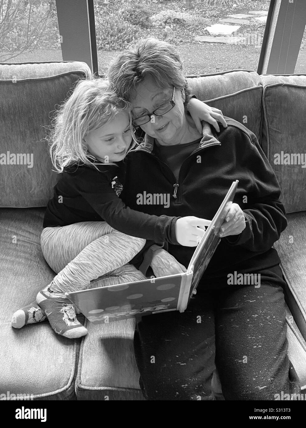 Grandparent reading a book to a grandchild Stock Photo