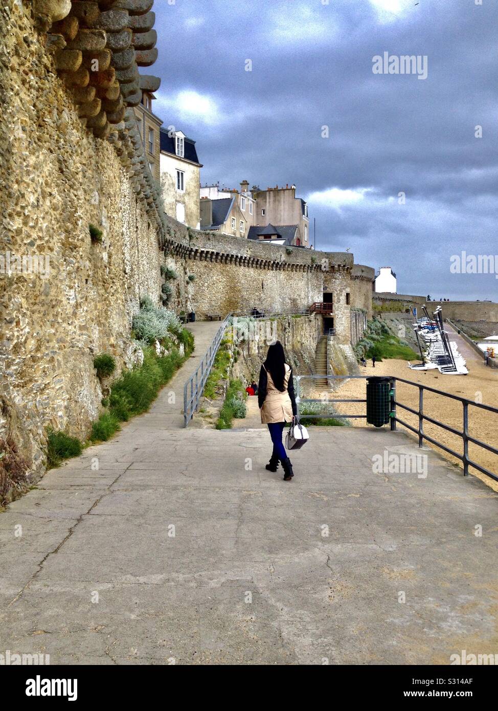 Saint-Malo scenic by the Fort Royal, renamed Fort National along the sea coast, with a local woman walking along the street, France. Stock Photo