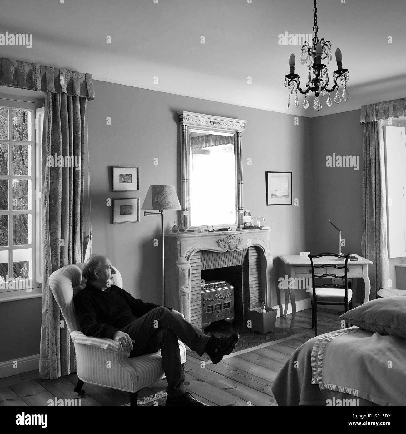 Man thinking by a fireplace in a rococo style room - Smartphone Captured Stock Image Man thinking by a fireplace in a rococo style room - Smartphone Captured Stock Image