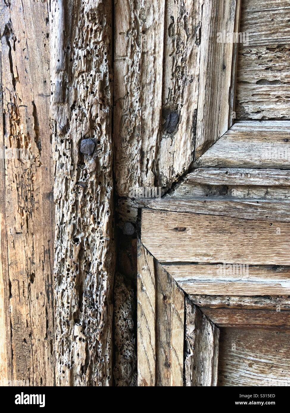 Close up showing the texture of a weathered old church door in Umbria, Italy. - Smartphone Captured Stock Image