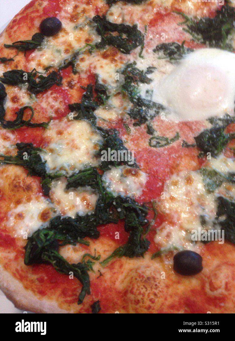 Pizza with spinach and a free range egg. - Smartphone Captured Stock Image