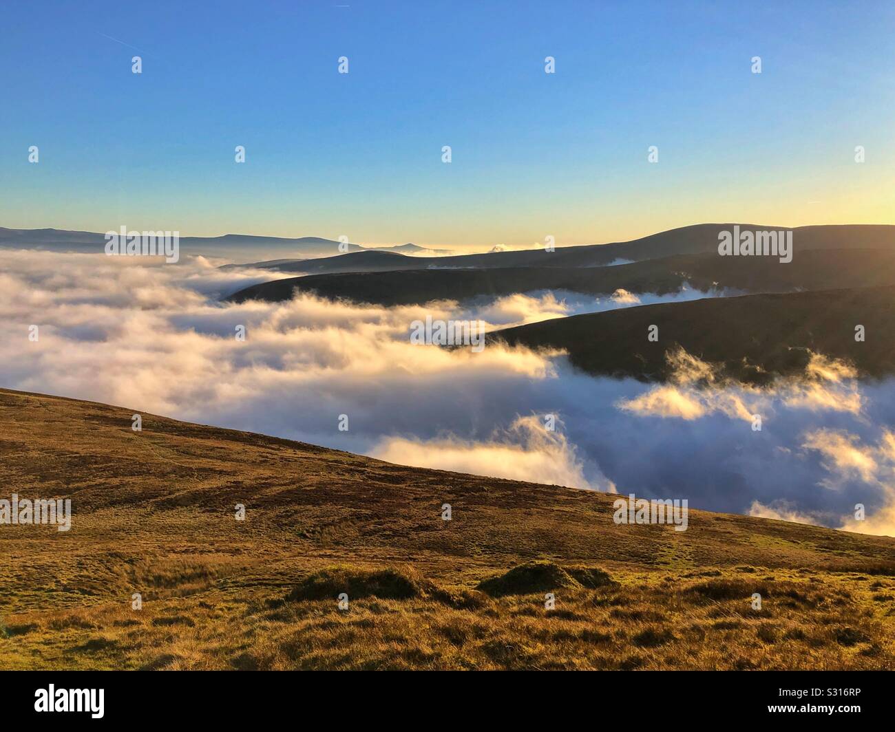 Early morning low lying cloud in the valleys around Pen y Fan, Brecon Beacons, Wales, December. Stock Photo