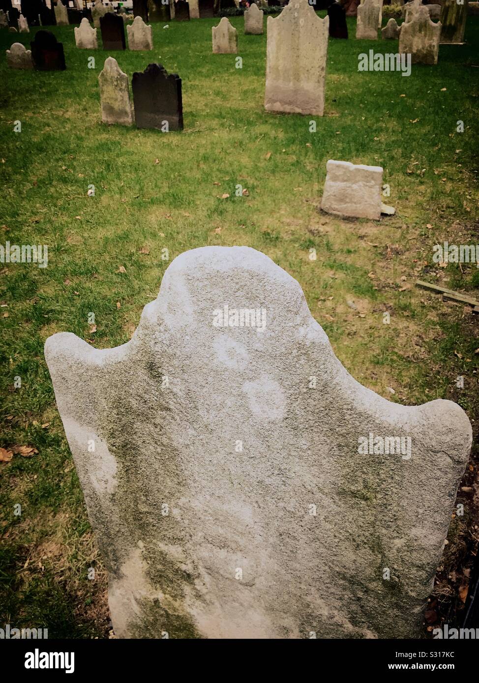 Tombstones worn smooth over the years in a cemetery grave yard, USA - Smartphone Captured Stock Image