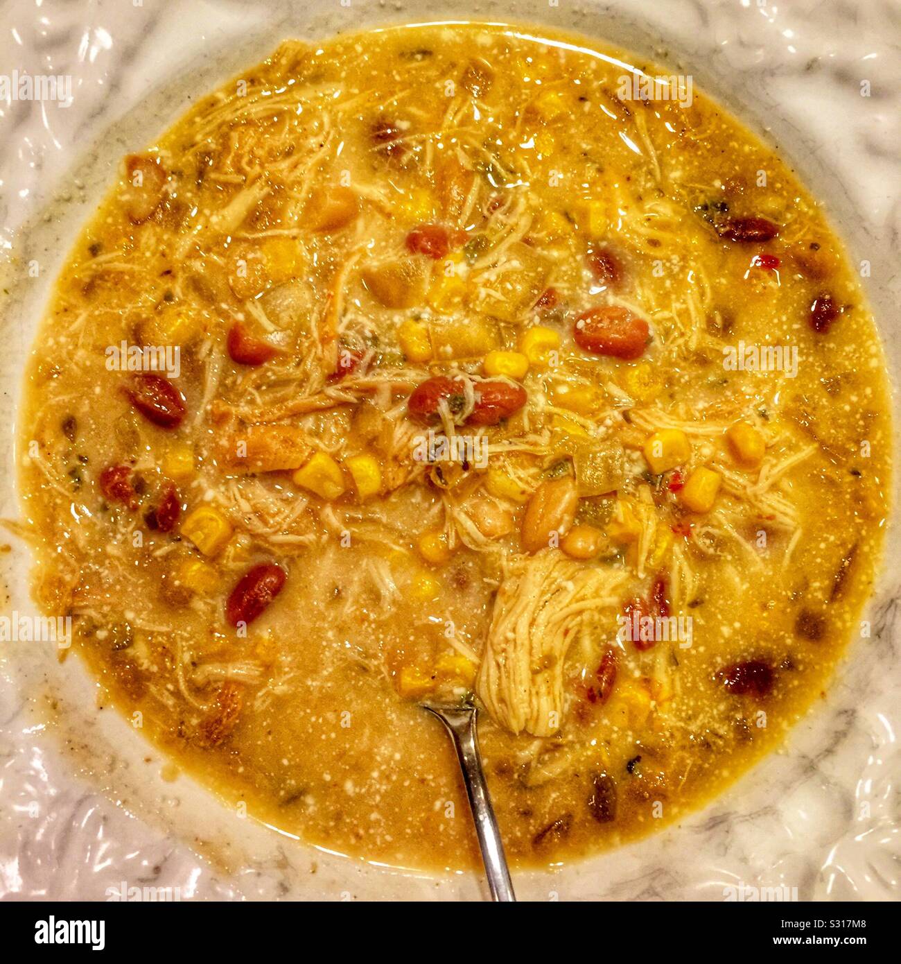Chicken chili in white bowl with spoon. Stock Photo