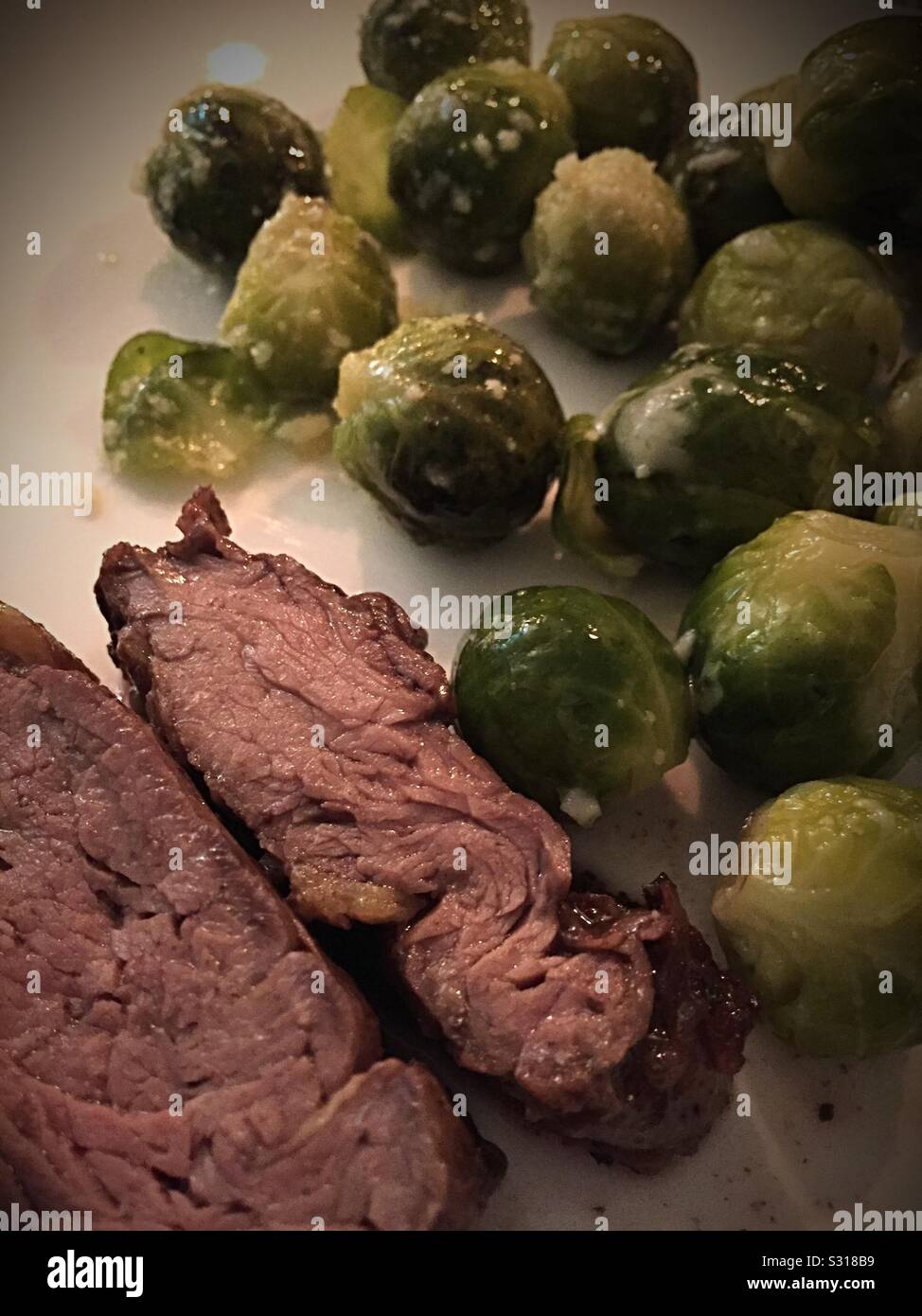 Close up of a hearty home cooked meal of beef tenderloin and steamed Brussels sprouts - Smartphone Captured Stock Image