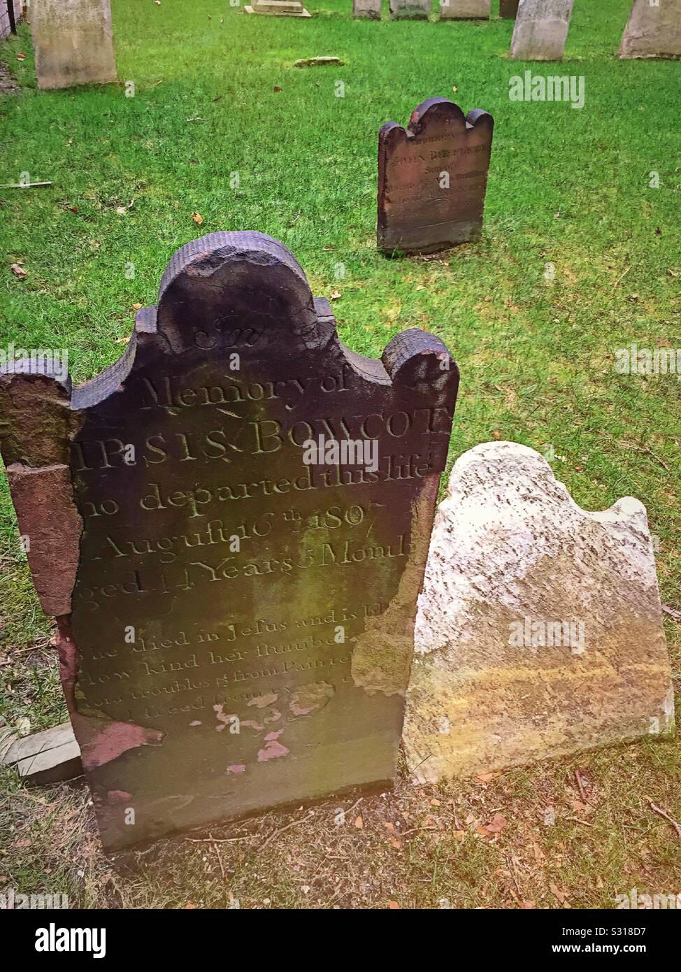 Ancient tombstones worn smooth by time in historic cemetery - Smartphone Captured Stock Image