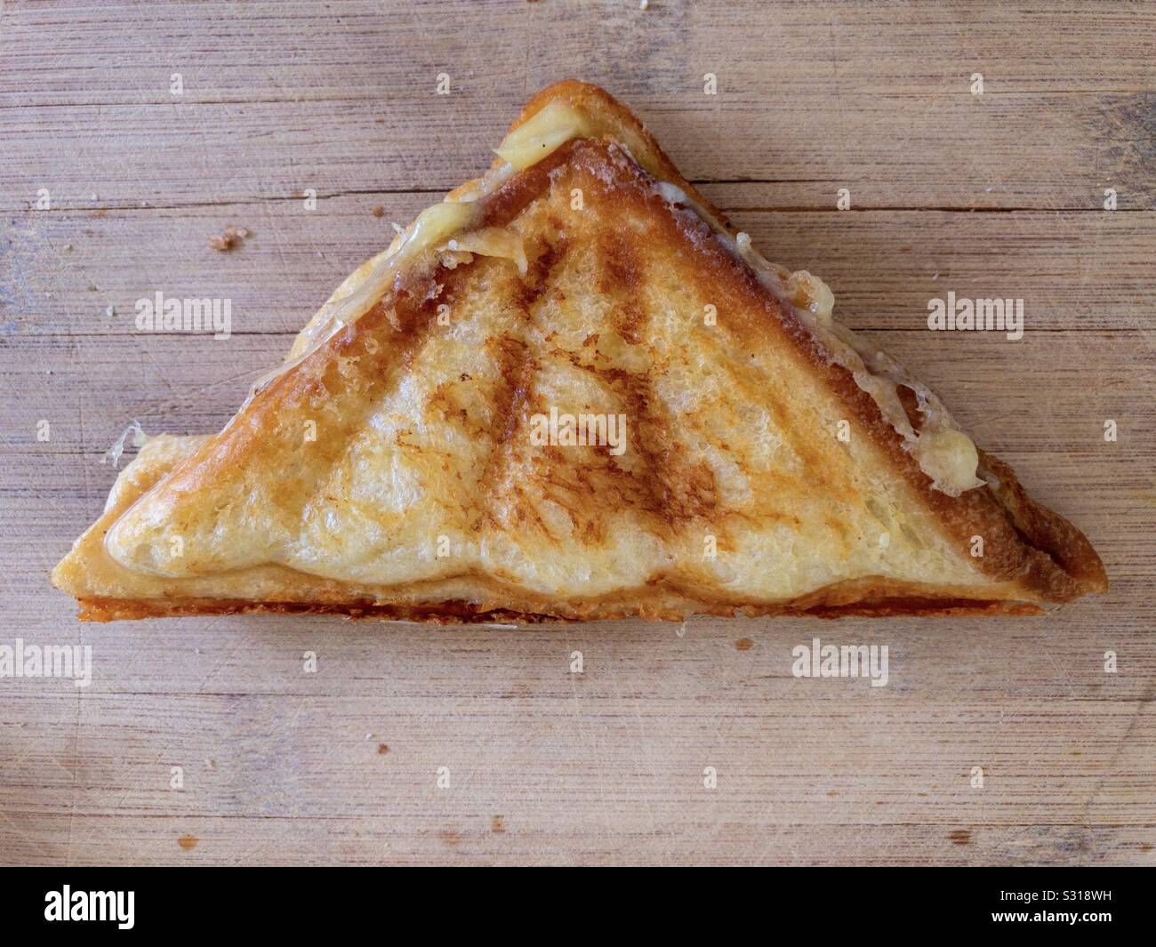 Toasted sandwich on a wooden cutting board. - Smartphone Captured Stock Image