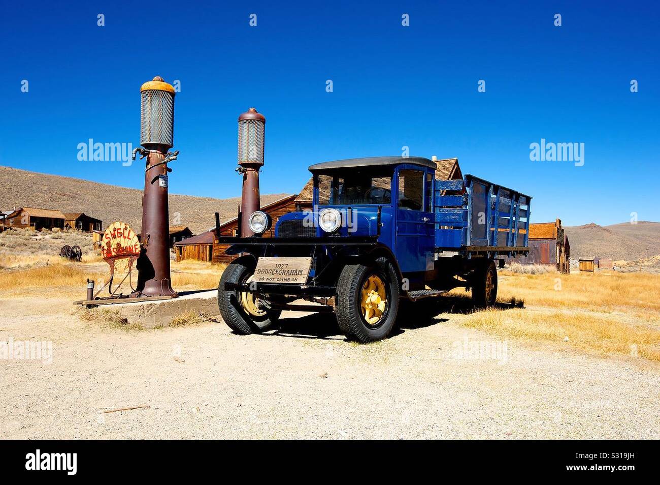 Well preserved old truck pulling up to an old gas pump in the historic town of Bodie, CA Stock Photo