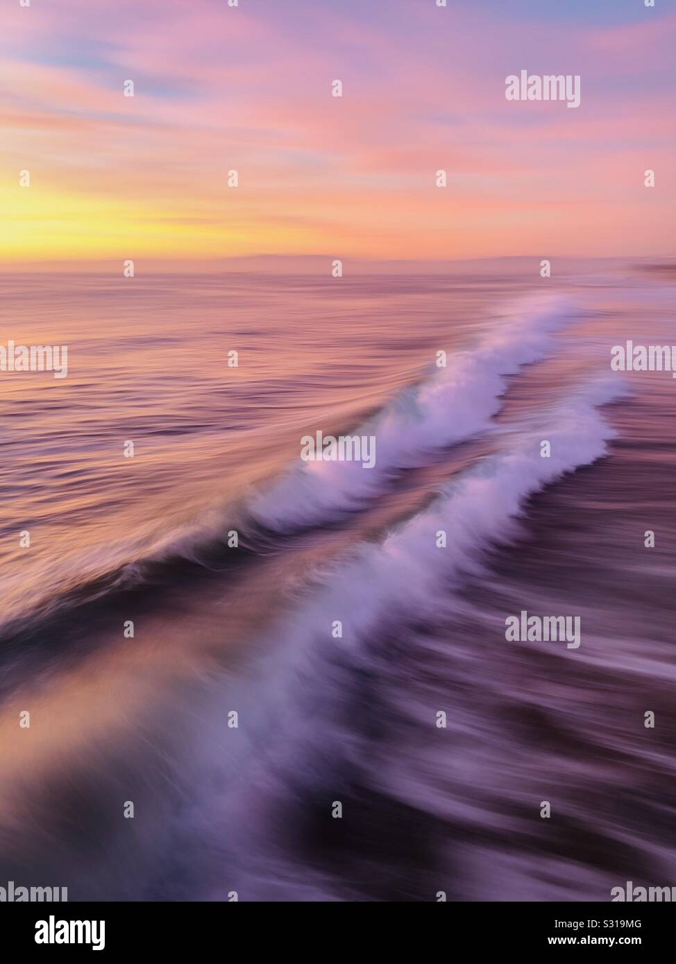 Artistic photo blur of waves breaking in the ocean at sunset. Manhattan Beach, California USA. - Smartphone Captured Stock Image