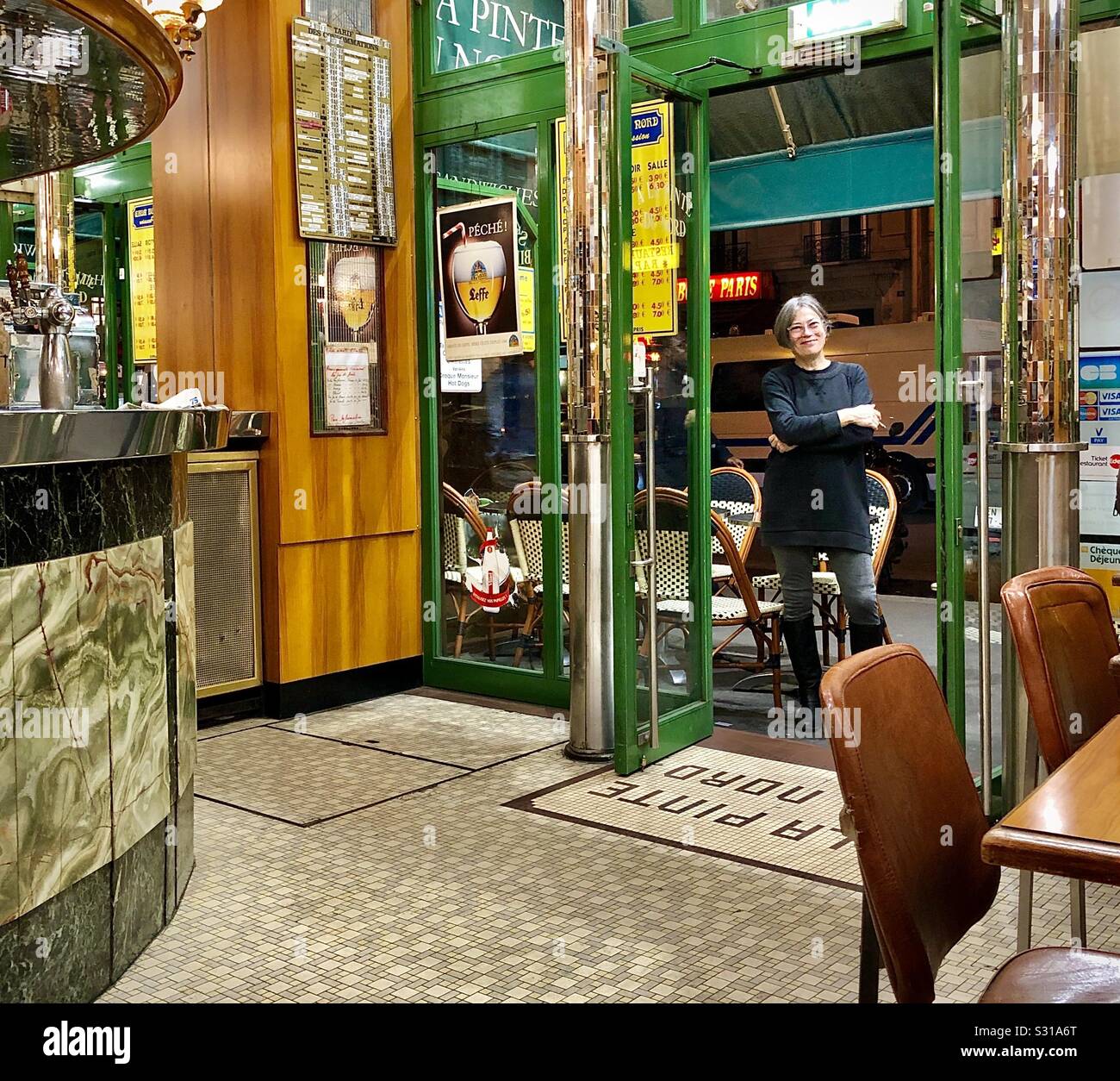 Woman smoking outside bar doorway, Paris, France. - Smartphone Captured Stock Image