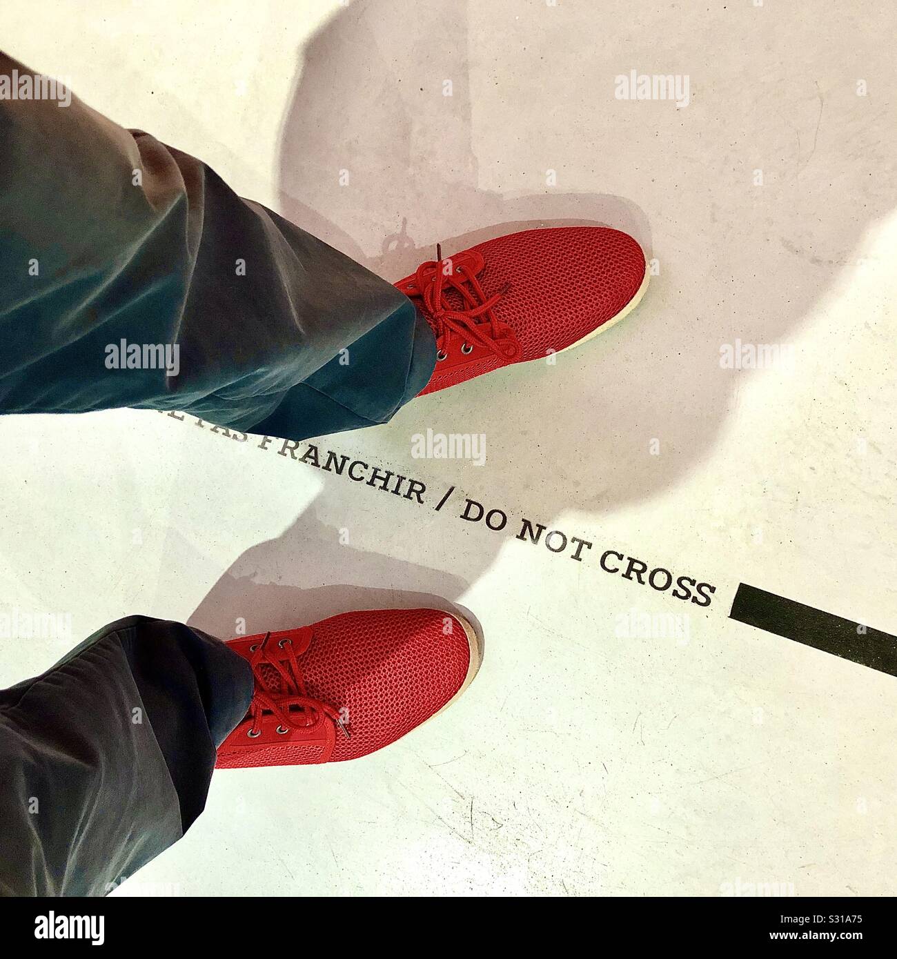 Stepping across a « Do not cross » line in art gallery - France. - Smartphone Captured Stock Image