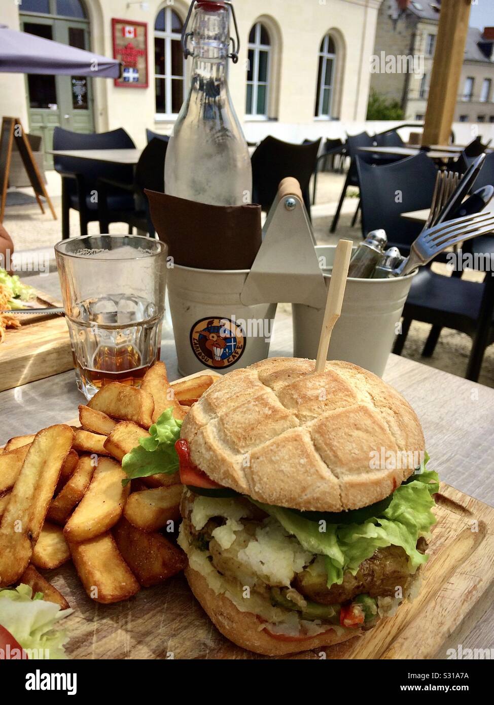 Vegan burger and chips lunch on restaurant terrace in France. - Smartphone Captured Stock Image