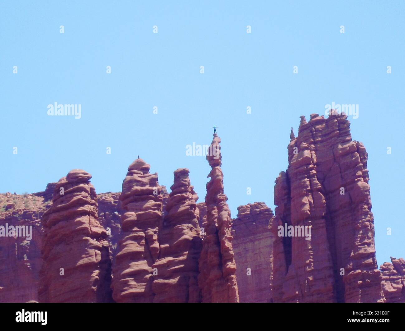 Climber standing on top of Ancient Art, Fisher Towers Stock Photo - Alamy