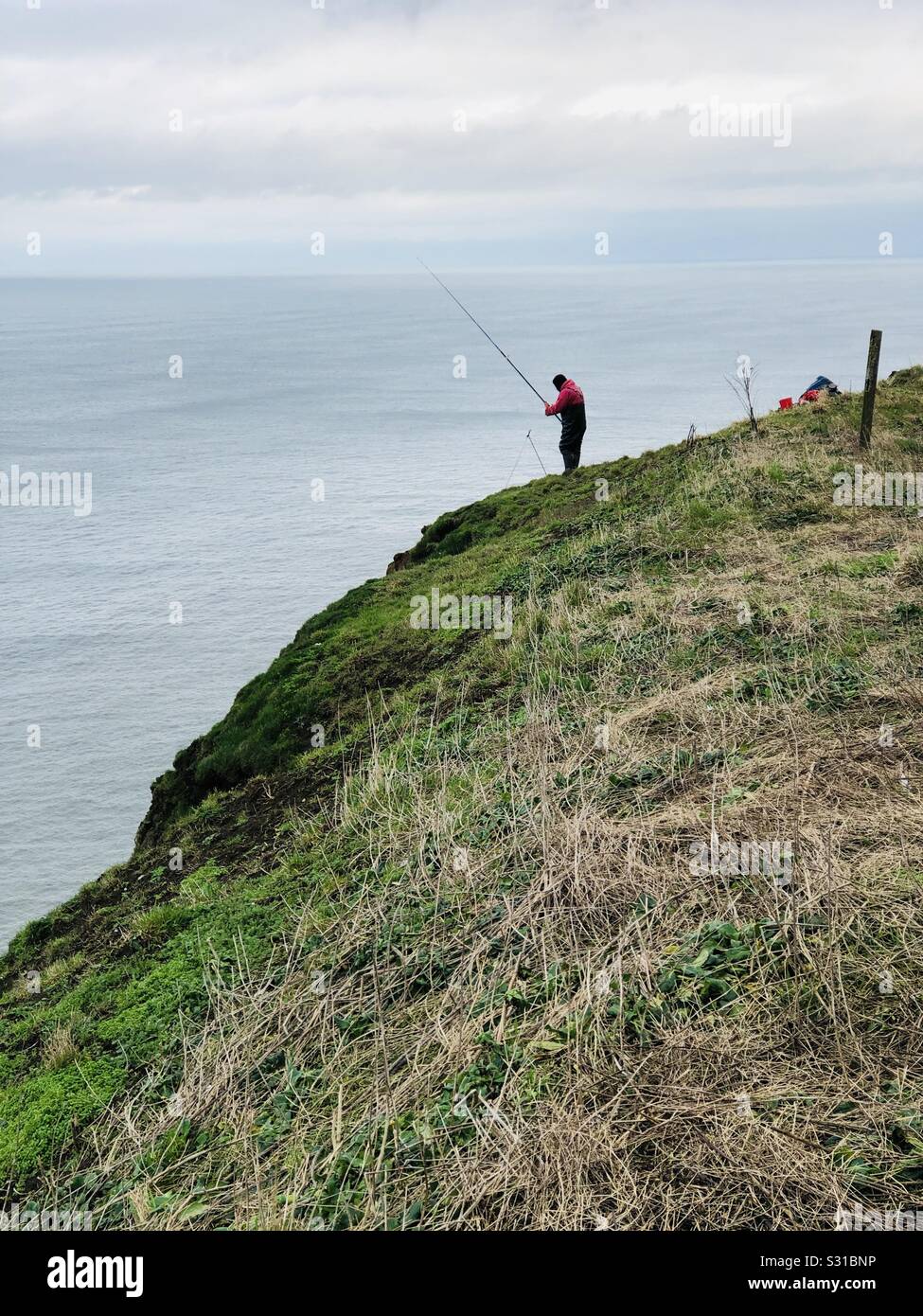Angler on top of a 300 ft cliff - Smartphone Captured Stock Image