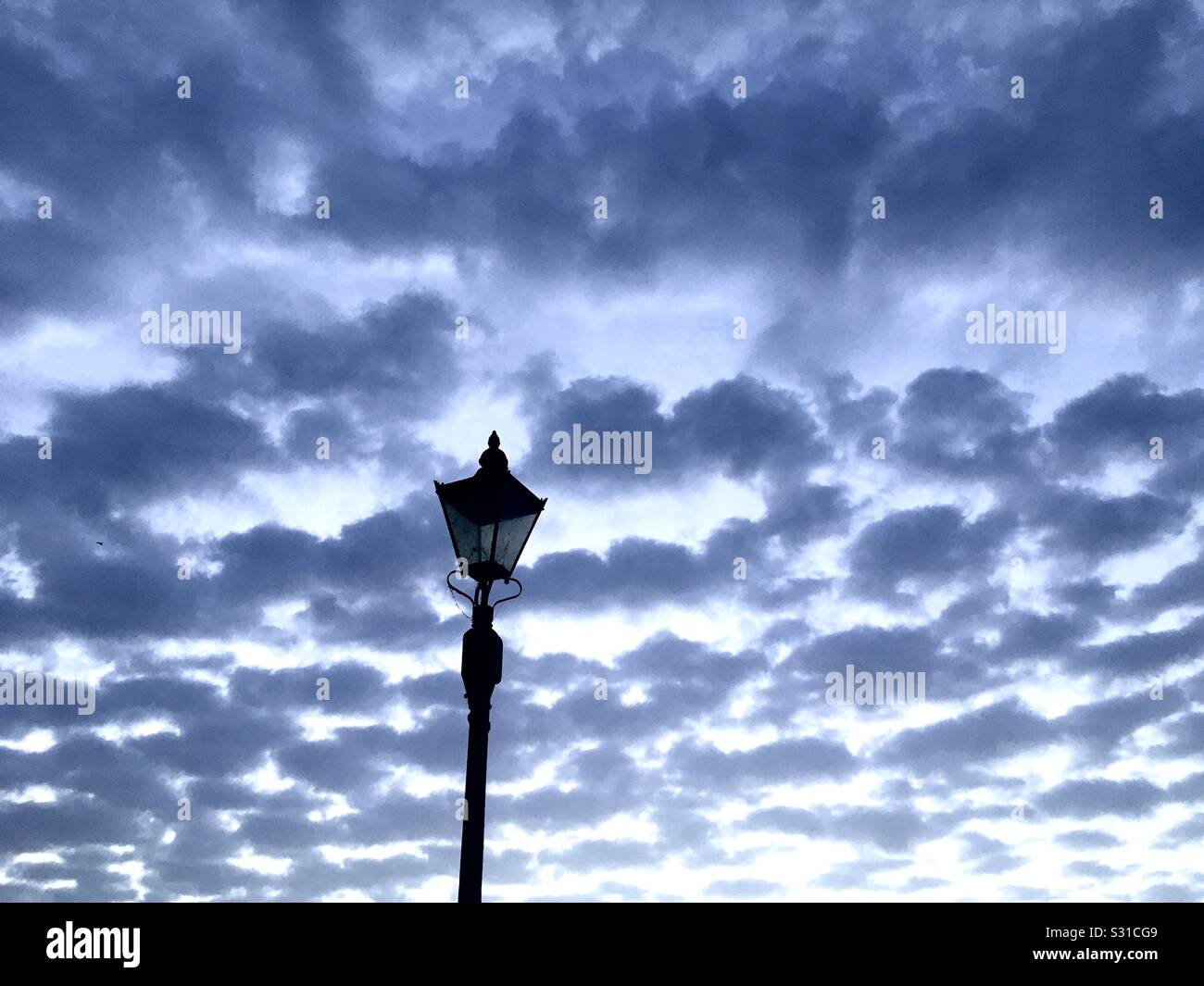 Morning clouds and lamppost Stock Photo