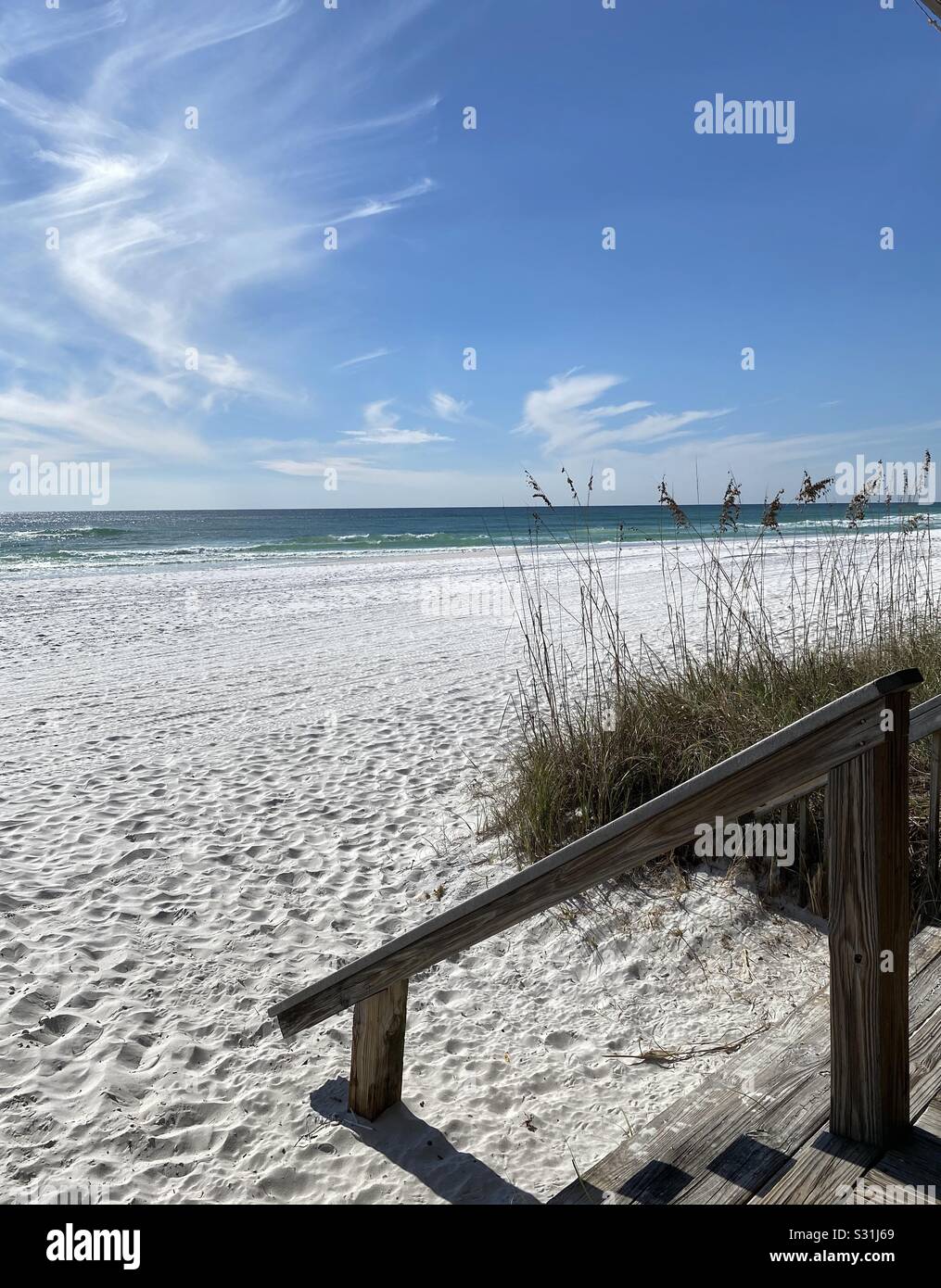 Seascape of white sand beach, wooden steps, emerald water and blue skies - Smartphone Captured Stock Image
