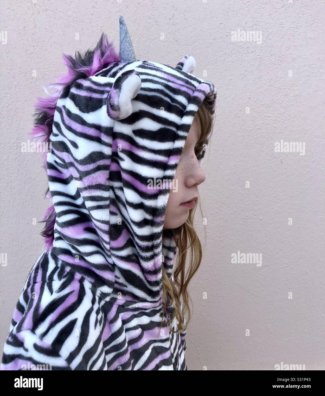 Child wearing a cosy unicorn onesie Stock Photo