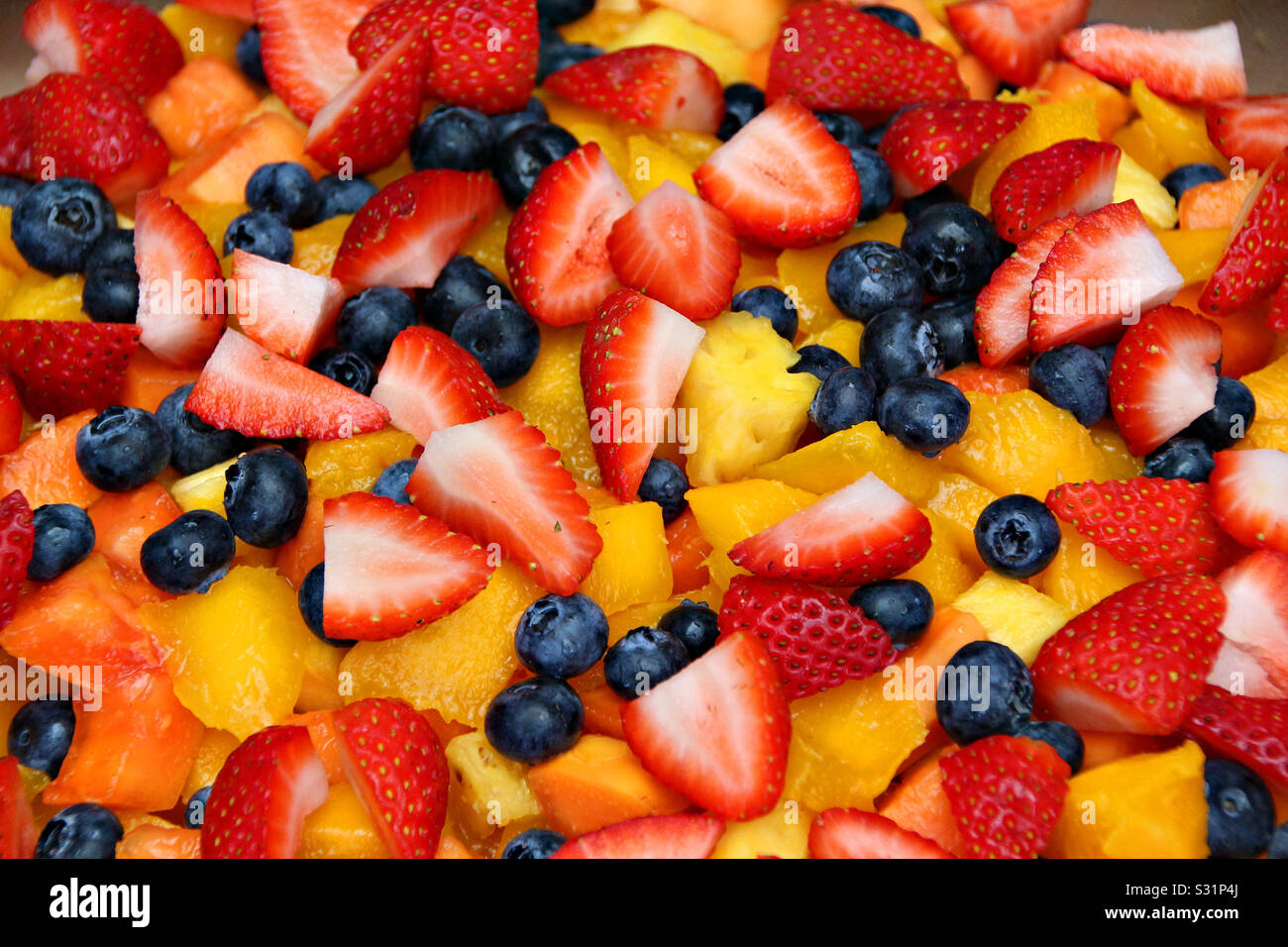 https://c8.alamy.com/comp/S31P4J/closeup-of-a-fruit-salad-with-strawberries-blueberries-orangesmango-melon-and-pineapple-S31P4J.jpg