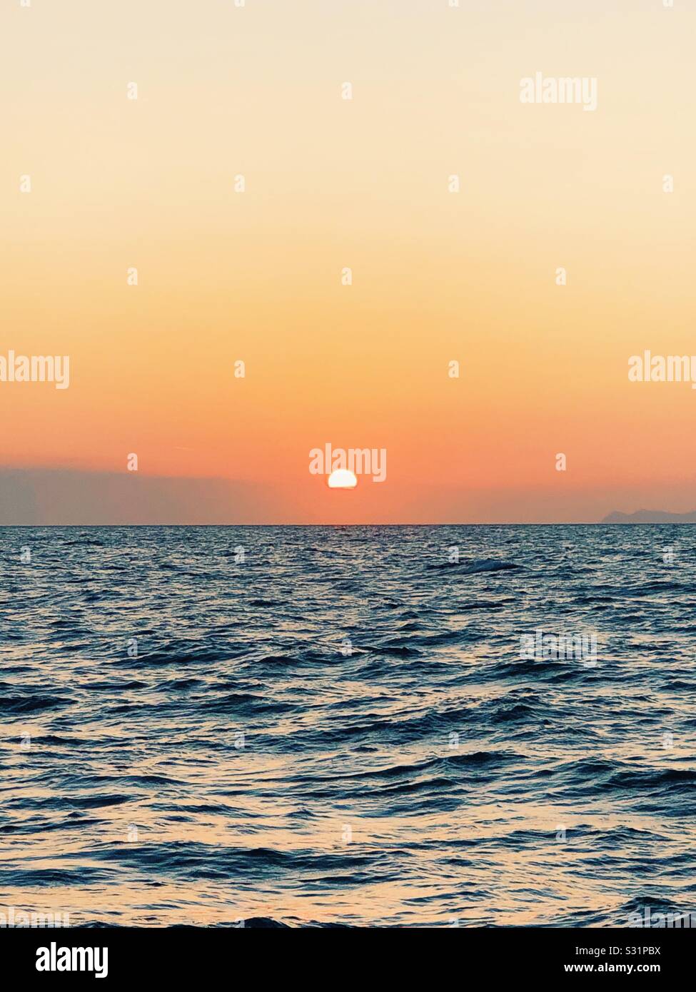 Sun setting into the sea hi-res stock photography and images - Alamy