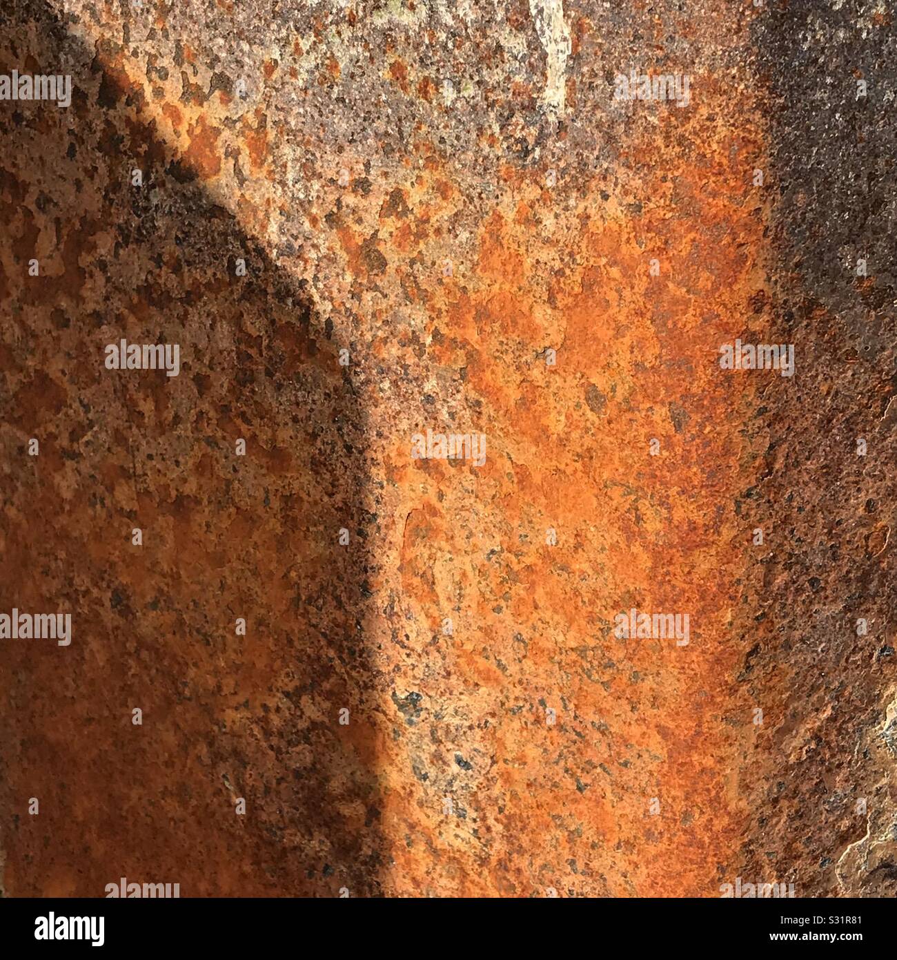 Bright orange steel rusting in nature. Close up textures and shadows - Smartphone Captured Stock Image