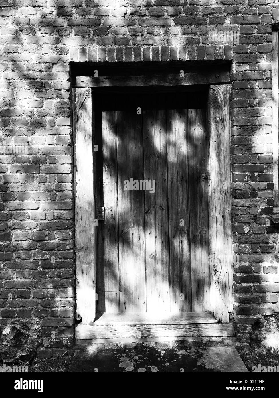 Old building exterior doorway casted in shadows. - Smartphone Captured Stock Image