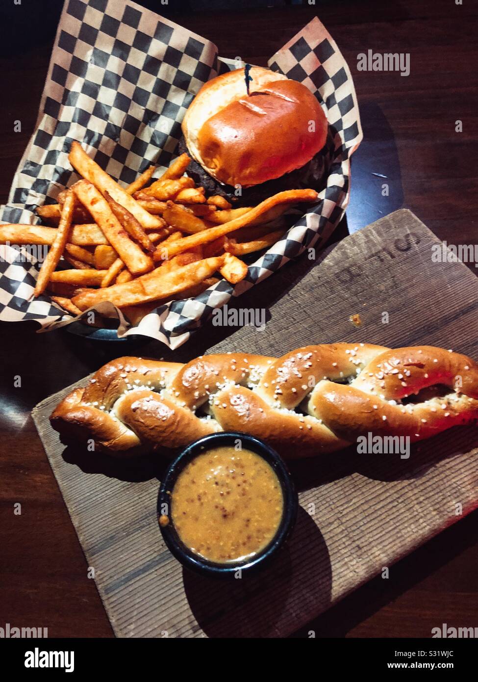 Great accompaniment for a beer - burger, fries and pretzel Stock Photo