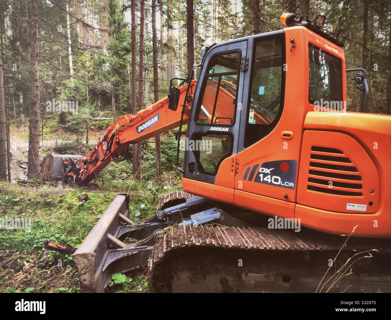Orange excavator in the Forest Stock Photo