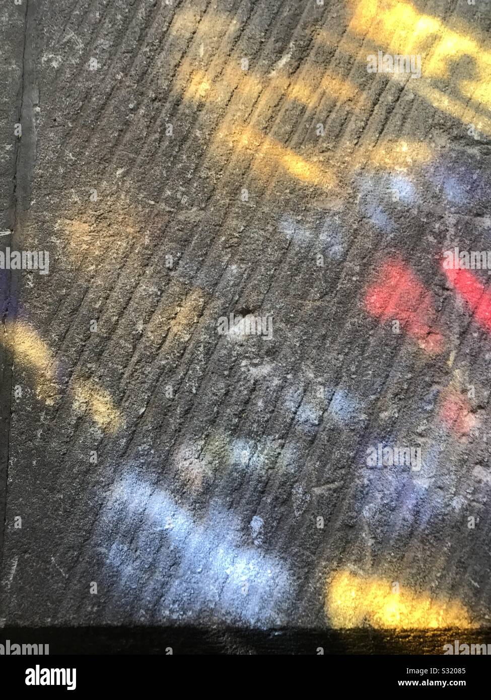 Stain glass window colour light reflecting on stone lintel - Smartphone Captured Stock Image